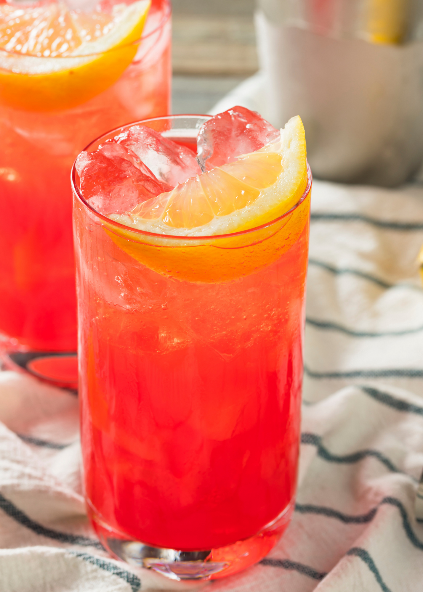 Alabama Slammer cocktail with orange wedge on a towel